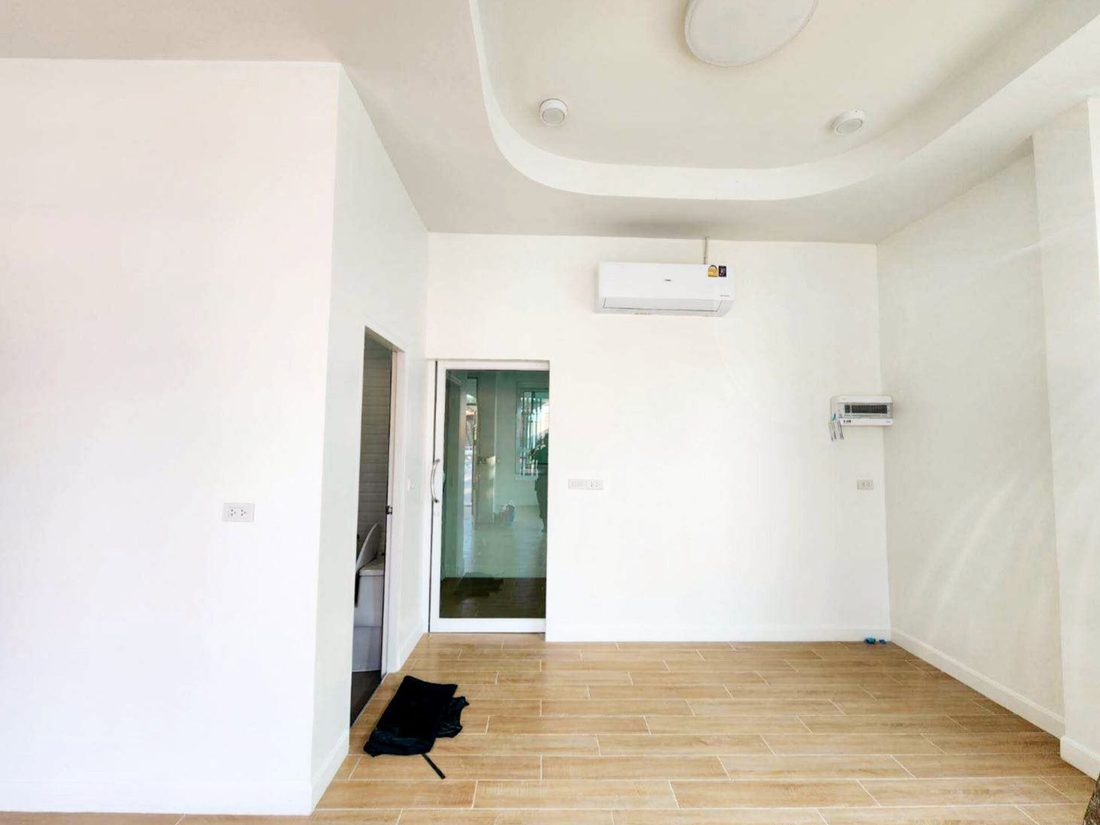 ห้องภายในบ้านที่ตกแต่งเสร็จ ฝ้าเพดานหลุมและประตูกระจกออกด้านหลัง