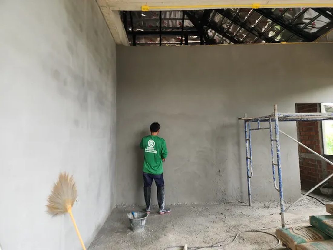 โครงการบ้านโมเดิร์นชั้นเดียว ช่างกำลังเก็บงานผนังภายในห้อง