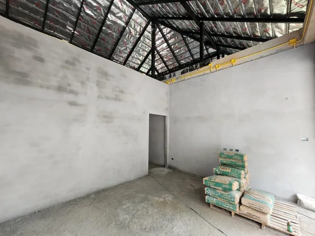 โครงการบ้านโมเดิร์นชั้นเดียว ภายในห้องเห็นช่องประตูและวัสดุก่อสร้างกองรอใช้งาน