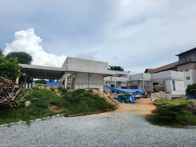 หน้างานก่อสร้างบ้านหลังใหญ่ มุมกว้างเห็นตัวอาคารระหว่างงานโครงสร้าง