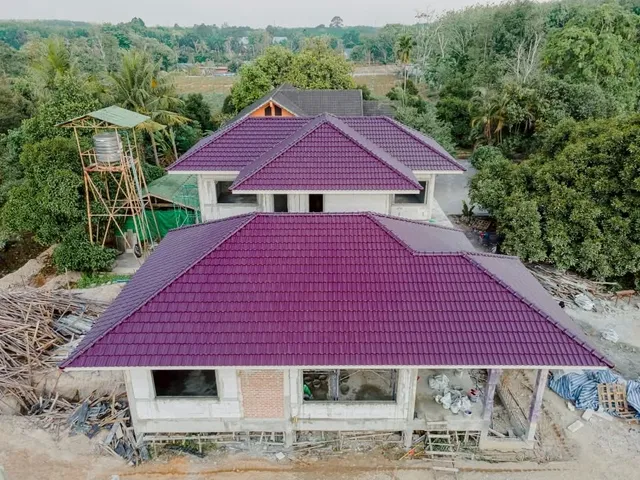 ภาพมุมสูงบ้านหลังใหญ่ เห็นแนวหลังคาและโครงสร้างผนังรอบอาคาร